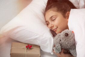 Adorable,Child,Girl,Sleeping,In,Her,Bed,With,Gift,Box