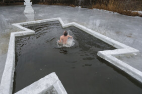 epaselect epa04568846 An Orthodox believer bathes in cold water during Epiphany celebrations in Kiev, Ukraine, 19 January 2015. During Epiphany, some people believe that the waters have special curative properties and can be used to treat various illnesses, and many of them take icy baths as part of its celebration.  EPA/SERGEY DOLZHENKO